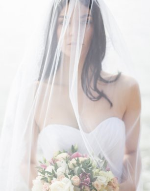 Невеста, голова которой покрыта фатой